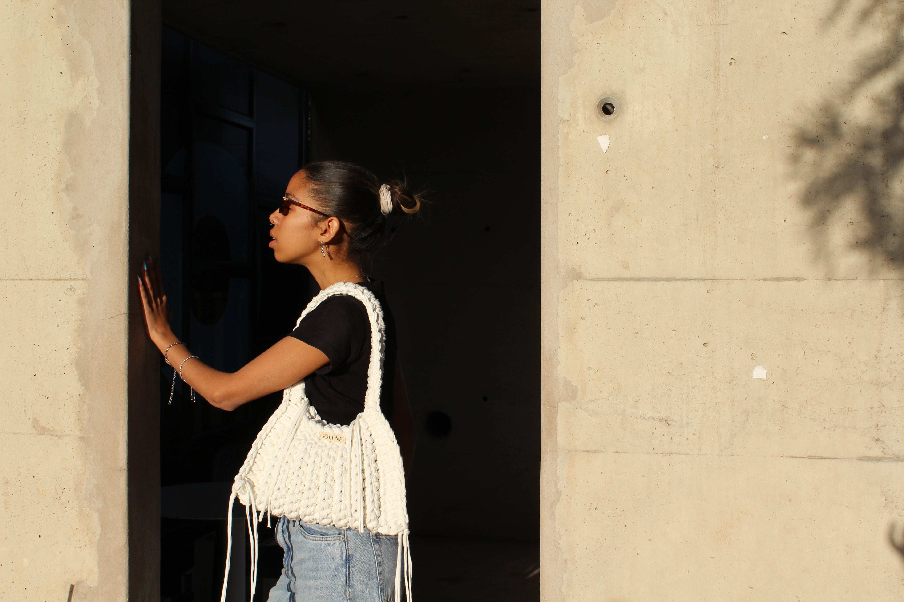 Person standing in a doorway with a textured wall background